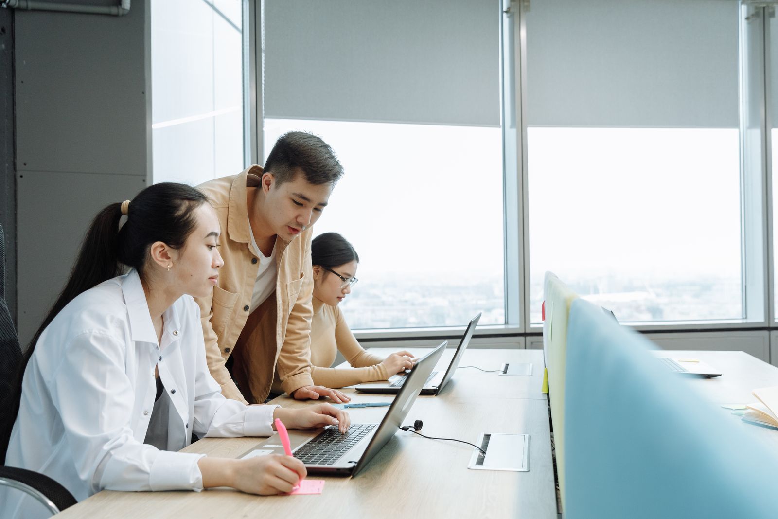 Colleagues working together at laptops in a bright office